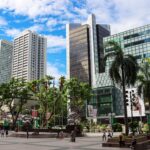 Explore the modern skyscrapers and bustling urban life of Singapore's cityscape under a bright blue sky.